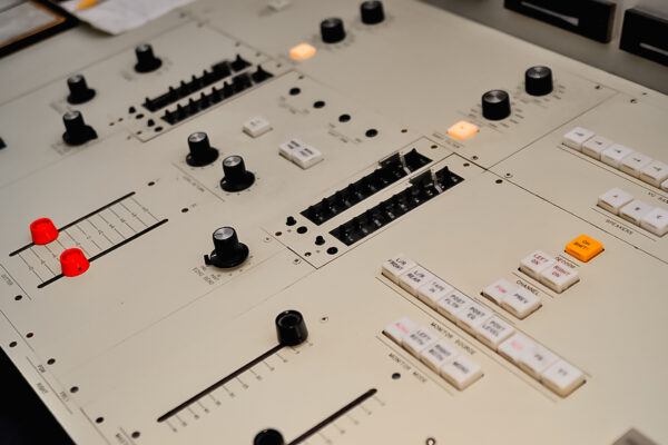 Digital mastering soundboard with buttons, dials, and controls