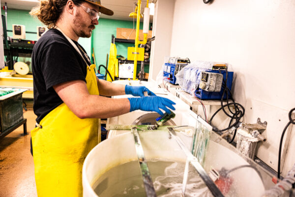 Plating employee cleaning metal parts