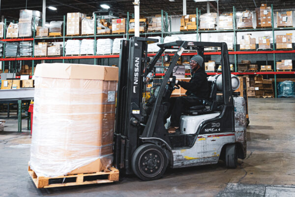 Worker using forklift to move pallet
