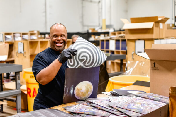 Worker inserting vinyl record into jacket