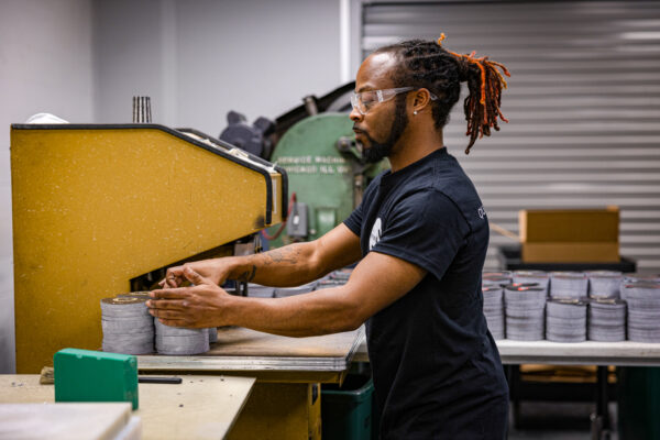 Employee standing at machine with printed materials