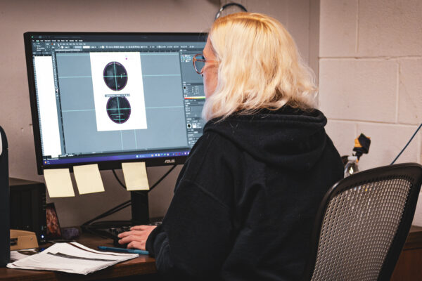 Worker at computer making adjustments to artwork