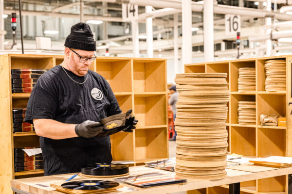 Worker inspecting vinyl records at a table