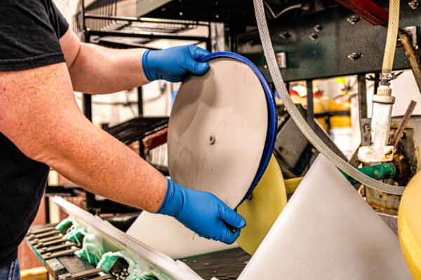 Worker setting up metal part for plating tank