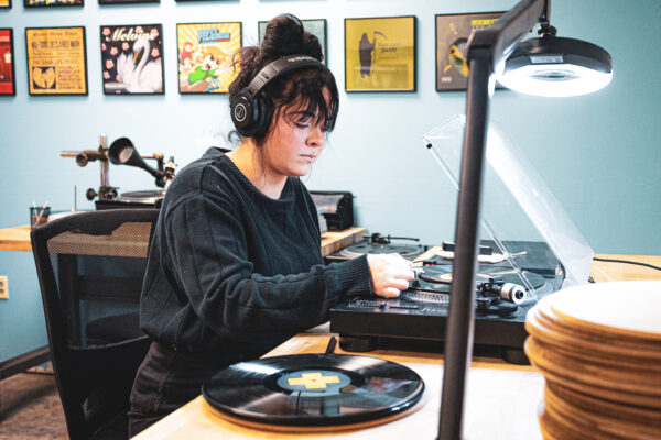 Worker listening to vinyl record with headphones on