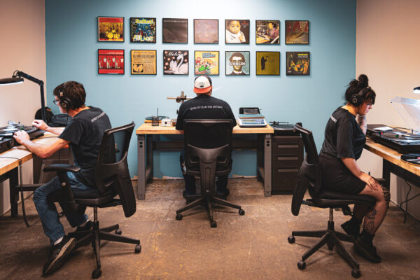 Three employees listening to records in office