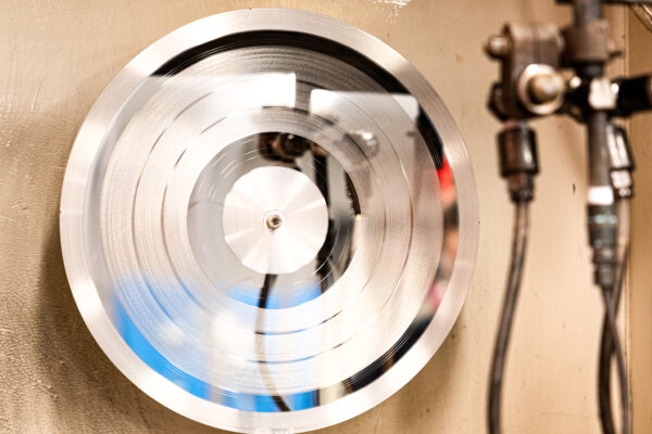 Lacquer disc being sprayed with silver during the silvering process