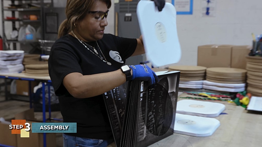 Inspecting vinyl record in cellular manufacturing of URP facility